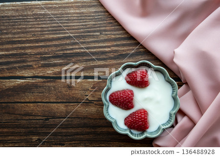 Natural white yogurt with raspberry berries in green plate, wood table and napkin for healthy breakfast.  136488928