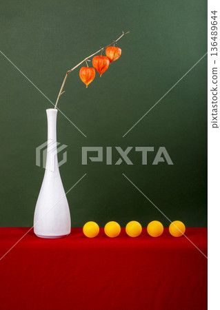 A branch of physalis in a white vase and yellow balloons 136489644