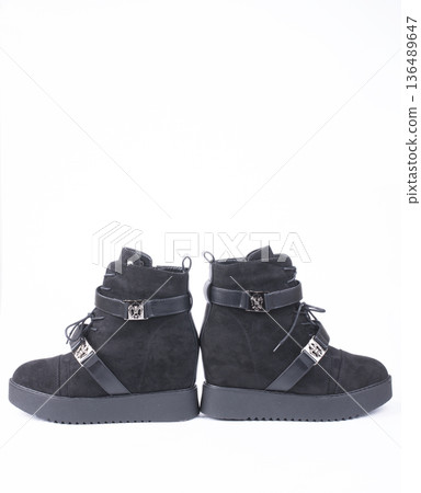 Female winter boots on high soles on a white background Female winter boots on high soles on a white background 136489647