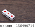 Three dice lined up on a wood grain background 136490714