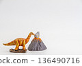 Long-necked dinosaur and volcano figures on white background 136490716