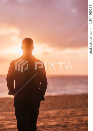 Man enjoying solitude on beach at sunset Man enjoying solitude on beach at sunset 136490988