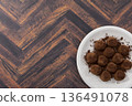 Chocolate truffles on a plate on a wood grain background 136491078