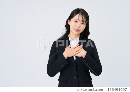 A businesswoman posing with her hand on her chest 136491097