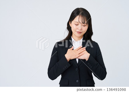 A businesswoman posing with her hand on her chest 136491098