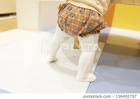 A baby's feet in baby tights. A baby's feet in baby tights. 136492787