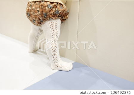 嬰兒穿著嬰兒褲襪的小腳。 嬰兒穿著嬰兒褲襪的小腳。 136492875