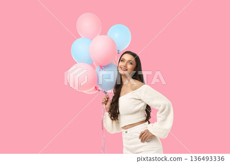 A woman holds colorful balloons during a birthday celebration 136493336