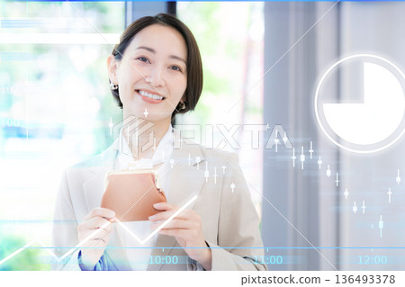 一對男女手拿錢包，正在思考資產管理，例如投資。他們正在研究K線圖、投資信託和股票投資。 136493378