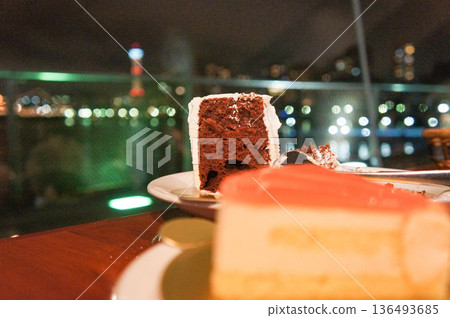 A luxurious moment of chocolate cake with the night view as a backdrop A luxurious moment of chocolate cake with the night view as a backdrop 136493685