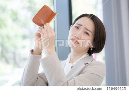 Sad and troubled image of working but not having money (lack of money). Prices are high, it's tough ~ I wonder if I'll be in the red this month too? Looking at the camera 136494625