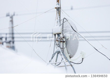 The back of a parabolic antenna and its wiring covered in snow (image of reception problems) The back of a parabolic antenna and its wiring covered in snow (image of reception problems) 136494650