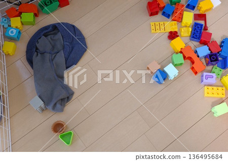 玩具積木和兒童衣服散落在地板上。 玩具積木和兒童衣服散落在地板上。 136495684