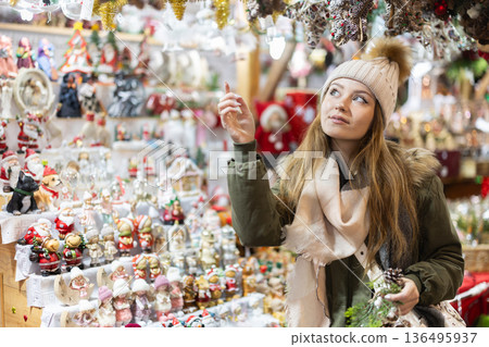 Young woman looking at decorated shop windows in the market 136495937