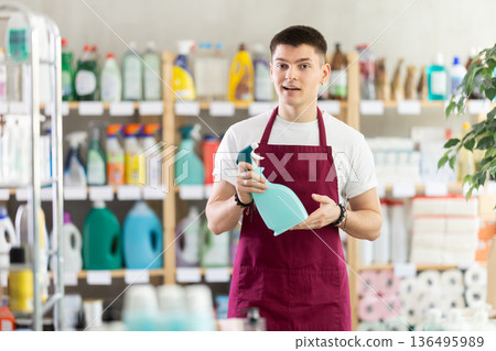 Young male seller offering cleaning spray 136495989