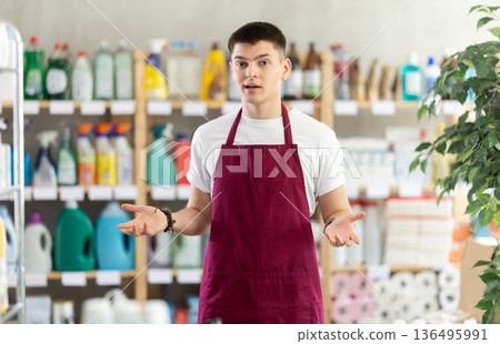 Young man seller in household chemicals store Young man seller in household chemicals store 136495991