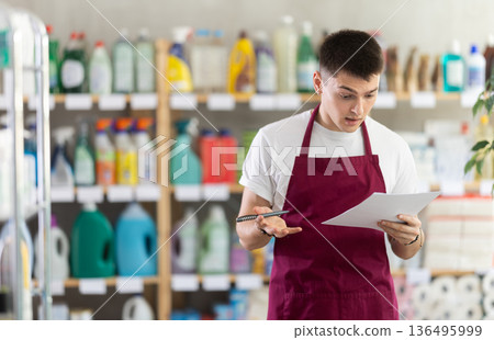 Anxious man seller with checklist in store Anxious man seller with checklist in store 136495999