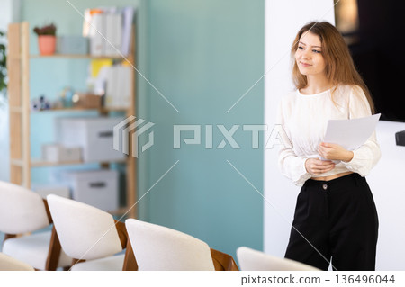 female coach with papers in her hands makes a presentation 136496044