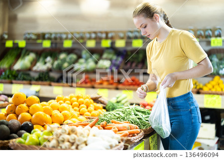 Teenage girl chooses green peas in store Teenage girl chooses green peas in store 136496094