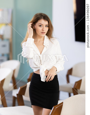 Girl playfully poses in classroom or lecture hall Girl playfully poses in classroom or lecture hall 136496097