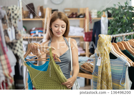 Girl customer choose tank top in store Girl customer choose tank top in store 136496200