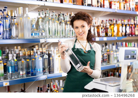 Woman seller offers to buy bottle of vodka Woman seller offers to buy bottle of vodka 136496268