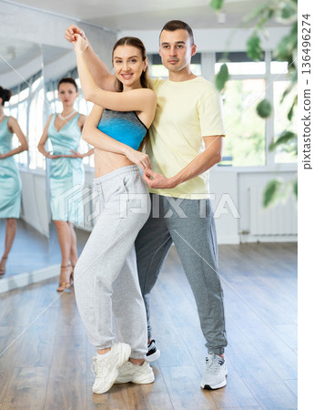 Couple in comfortable sports clothes waltz dancing during individual lesson 136496274