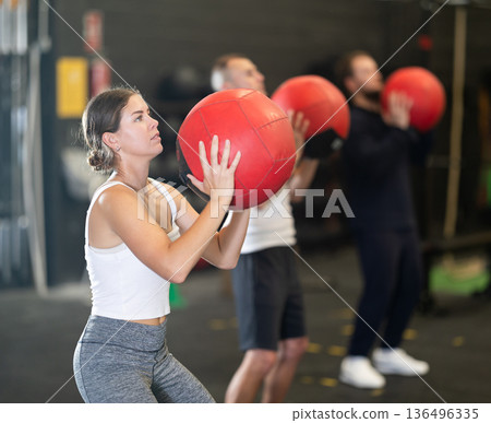 Girl performing intense cross workout with medicine ball 136496335