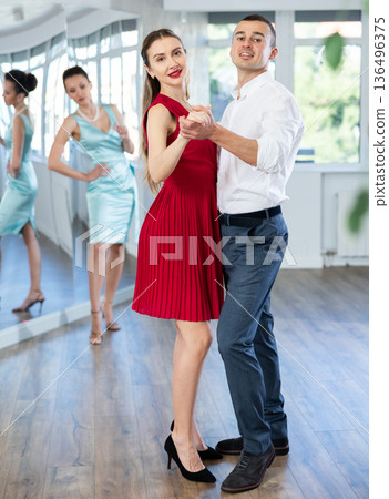 Couple in stage costumes learns boogie woogie dancing during individual lesson 136496375