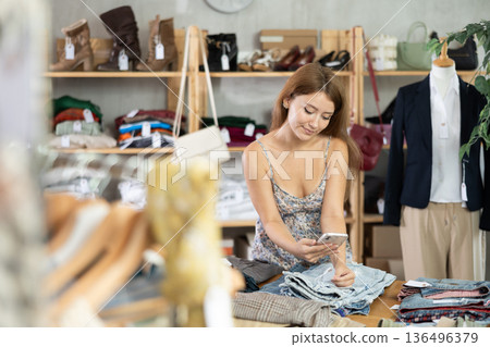 Young woman scanning barcode of jeans in store 136496379