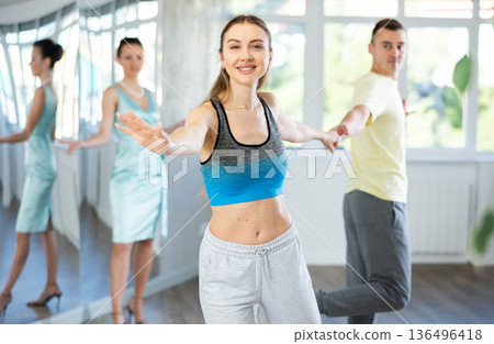 Couple in comfortable sports clothes learns boogie woogie dancing during individual lesson 136496418