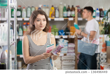 Girl view trademark sign on label, pick eco friendly razor, man shopping in background Girl view trademark sign on label, pick eco friendly razor, man shopping in background 136496449