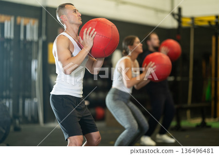 Sportive young guy working out with medicine ball in gym during crossfit workout 136496481
