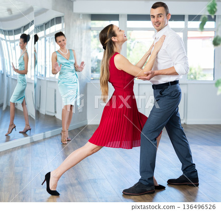 Couple in stage costumes learns waltz dancing during individual lesson 136496526