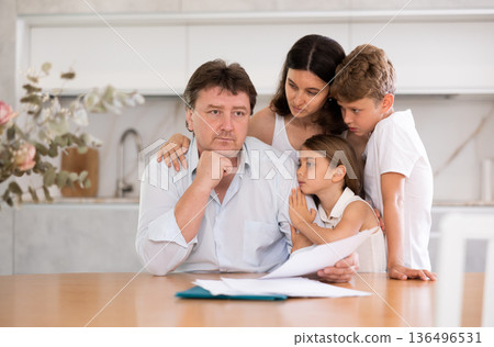 Woman with husband carefully reads sad news in financial family business report at home Woman with husband carefully reads sad news in financial family business report at home 136496531
