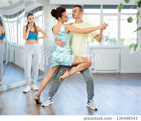 Female dance instructor showcasing tango moves with male student 136496543