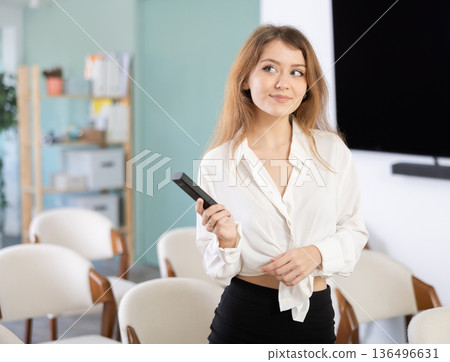 Girl teacher speaker with remote control during lecture 136496631