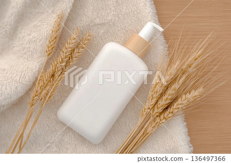 A white plastic container with a dispenser containing wheat on a white towel. Natural cosmetics. Top view. A white plastic container with a dispenser containing wheat on a white towel. Natural cosmetics. Top view. 136497366
