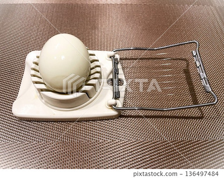 Slice the boiled egg with an egg cutter3 Slice the boiled egg with an egg cutter3 136497484