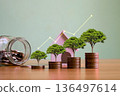 Financial growth and real estate investment concept featuring money trees on rising coin stacks, a house model, and an upward trending graph. Ideal for wealth management, savings, retirement planning, 136497614