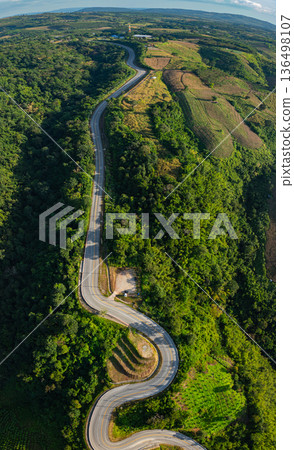 Aerial View of a Serpentine Mountain Road Through Lush Green Forests Aerial View of a Serpentine Mountain Road Through Lush Green Forests 136498107