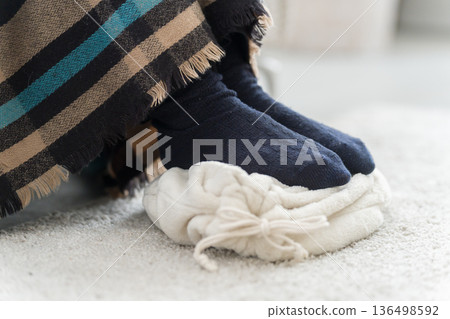 一位腳冷的女士正在使用熱水袋 136498592