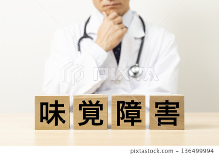 A doctor worries about a block that reads "taste disorder" A doctor worries about a block that reads "taste disorder" 136499994