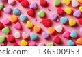 Playful Valentine's background: scattered conversation heart candies in bright colors against a light pink background. 136500953
