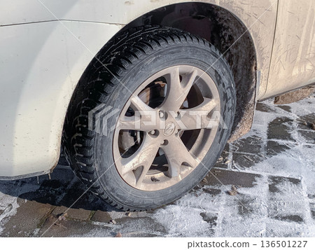 Dirty car wheel with melted snow Dirty car wheel with melted snow 136501227