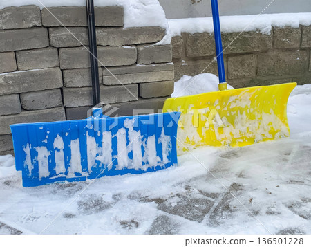 Snow shovels are standing outside Snow shovels are standing outside 136501228
