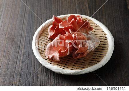 Yellow oyster mushrooms in a colander with a wood grain background 136501331
