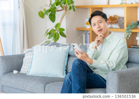 一個操作智能手機的人 136501536