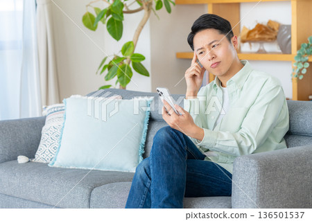 一個操作智能手機的人 136501537