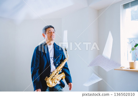 Senior man practicing the saxophone at home Senior man practicing the saxophone at home 136502010